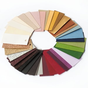 Puede incluir: Un abanico de colores con una variedad de colores, incluyendo beige, marr&oacute;n, dorado, verde, azul y rojo.