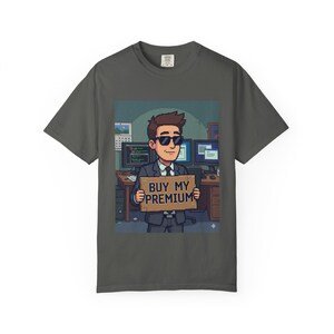 Peut inclure: T-shirt gris foncé avec une illustration de dessin animé d'une personne en costume et lunettes de soleil tenant une pancarte avec l'inscription "BUY MY PREMIUM". L'image comprend des écrans d'ordinateur et un bureau.