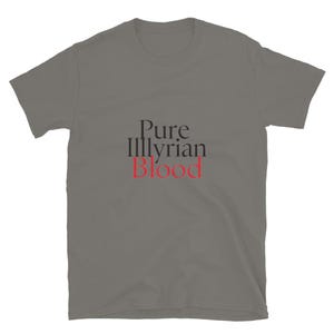 Puede incluir: Una camiseta gris con el texto "Pure Illyrian Blood" en negro y rojo. La camiseta está hecha de un material suave, con mangas cortas y cuello redondo.