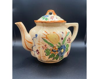 Théière vintage peinte à la main avec un motif floral.