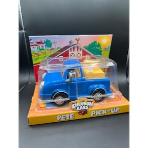 May include: A blue toy pickup truck, "Pete Pick-Up", in a clear plastic case. The truck has a yellow bed and black tires. The packaging features a farm scene with a red barn and a rooster.