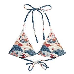 Könnte beinhalten: Ein Bikini-Oberteil mit cremefarbenem Hintergrund und einem wiederkehrenden Muster aus blauen Wellen, roten und weißen Fächern sowie kleinen rosa Kirschblütenzweigen. Das Kleidungsstück hat dreieckige Cups, dünne Halter-Bänder und eine Bindung.
