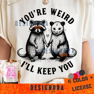 May include: Cream-colored t-shirt featuring a raccoon and opossum holding hands, with the text "YOU'RE WEIRD I'LL KEEP YOU" in black. A small heart is between the animals. The design includes a "4 COLOR + LICENSE" graphic.