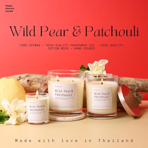May include: Three lit Wild Pear & Patchouli scented candles in glass jars. The candles are on a light-coloured surface with a red background. The text on the candles reads "Wild Pear & Patchouli". The text "Made with love in Thailand" is also visible.