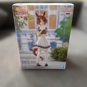 May include: A rectangular product box featuring a Bandai Namco Banpresto anime figure of a character with brown hair, horse ears, and a tail. The character wears a blue and white school uniform with a pleated skirt, white knee-high socks, and shoes.