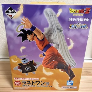 May include: A box featuring a Dragon Ball Z Masterlise figure of Goku with angel wings and a halo. The figure is in an orange and blue outfit. The box also shows a smaller figure and Japanese text.