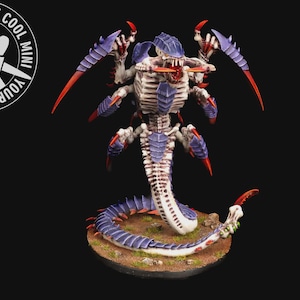 May include: A detailed miniature figure of a creature with a segmented body, purple armor, and red claws. The figure is on a circular base with a brown and green surface. The figure has the text "YOUR NEXT COOL MINI" in a circle.