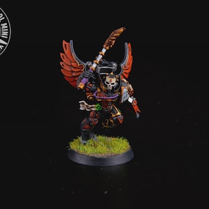 May include: Miniature figurine of a warrior in black, red, and gold armor, with a skull-shaped helmet and feathered wings. The figure is holding a staff and stands on a base with green grass. The logo "YOUR NEXT COOL MINI" is in the upper left.