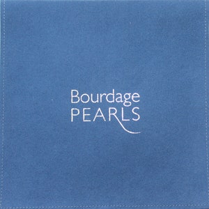 Pu&ograve; includere: Una bustina quadrata in tessuto blu con cuciture visibili lungo i bordi. Il testo Bourdage PEARLS &egrave; stampato in bianco al centro, con una linea stilizzata che si estende dalla lettera L, creando una presentazione pulita e semplice.