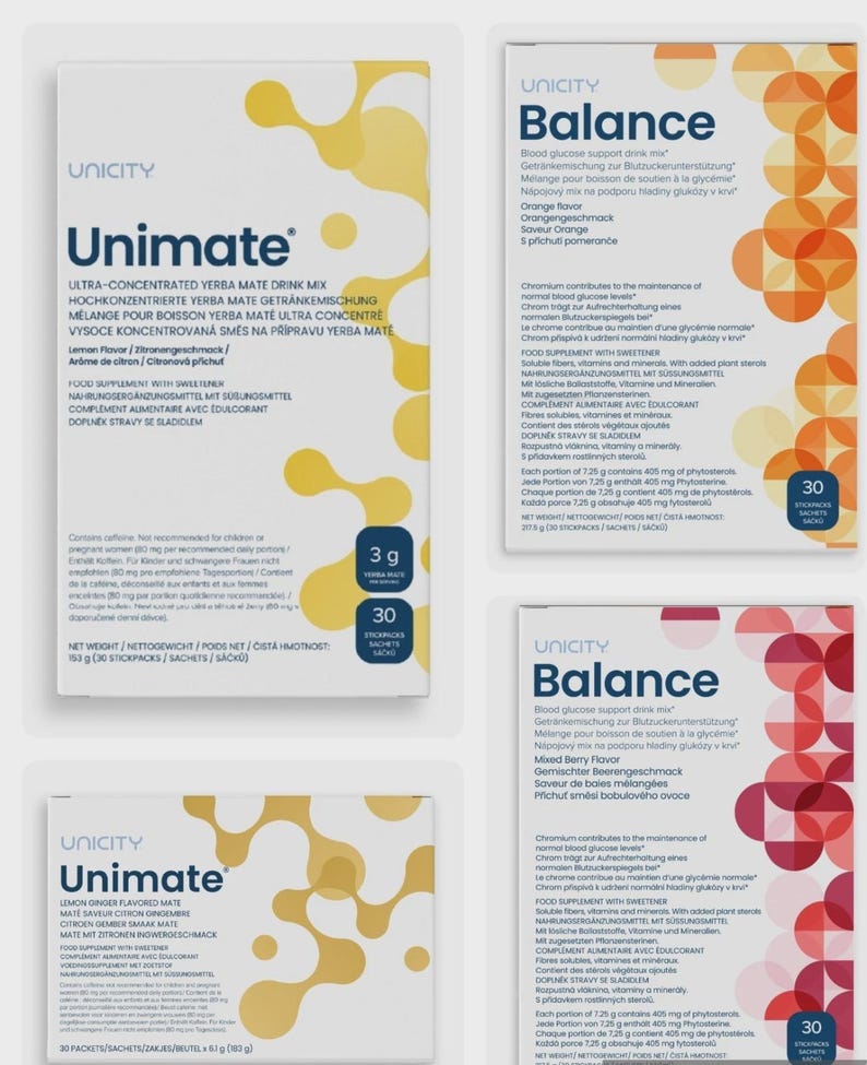Op de afbeelding: Verschillende dozen Unicity voedingssupplementen worden getoond. De witte dozen hebben tekst in verschillende talen en kleurrijke ontwerpen. Smaakvarianten zijn Citroen Gember, Sinaasappel en Gemengde Bessen. Elke doos bevat 30 zakjes.