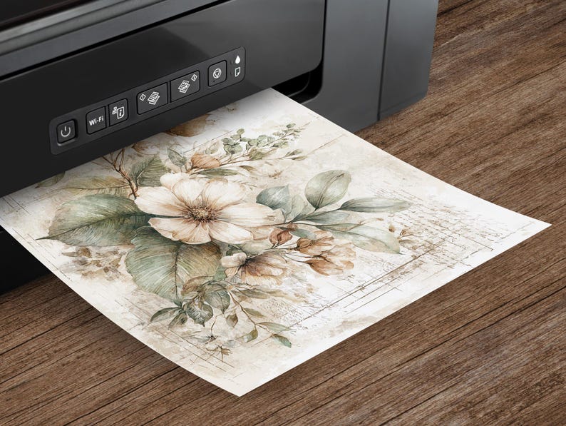 May include: A black printer is printing a watercolor floral design on paper. The artwork features large, cream-colored flowers, green leaves, and smaller brown buds. The paper has a vintage, aged appearance with faint script in the background.