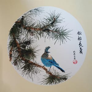 May include: A circular ink and watercolor painting on paper featuring a blue jay with a crest perched on a brown pine branch with green needles and small cones. The artwork includes black Chinese calligraphy characters and a red circular seal stamp.