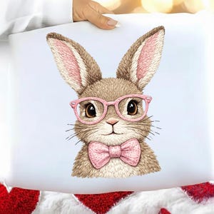 May include: A whimsical illustration of a bunny wearing pink glasses and a matching bow tie. The bunny has brown fur with pink accents on its ears. The image is on a white background, perfect for Easter or spring decor.