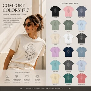 May include: A Comfort Colors 1717 premium garment-dyed t-shirt featuring a dreamcatcher graphic with butterflies. The shirt is shown in ivory, with a colour chart displaying 15 available options including black, blossom, blue jean, sage, moss, light blue, ivory, white, pepper, orchid, navy, flo blue, seafoam, graphite, chambray, butter, emerald, and watermelon.