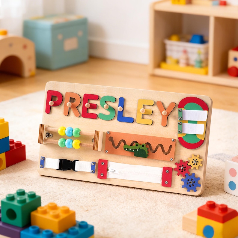 May include: Wooden activity board with the name "PRESLEY" spelled out in colorful letters. Features include an abacus, zipper, buckle, and gears. A green alligator is also present. Designed for early childhood development.