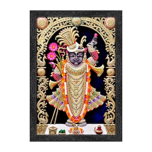 May include: A framed artwork depicting a deity in ornate attire, holding flowers and a flute. The figure is adorned with gold jewelry and a crown, set against a dark blue background. The frame is black with intricate gold detailing.