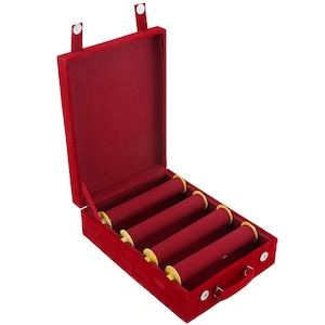 May include: A red velvet jewelry box with four cylindrical display bars. The box is open, revealing a plush interior. The box has a handle and two snap closures. The display bars are red with yellow ends.