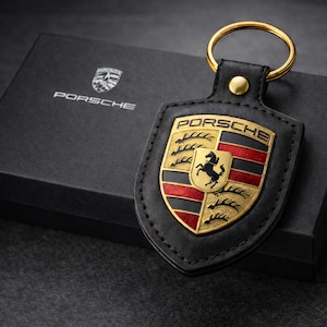 Luxury Porsche black keychain presented in a premium gift box, designed for car enthusiasts and lovers of sleek automotive accessories. This elegant key chain features a refined black finish that captures a modern sophisticated look while reflecting the prestige and performance-inspired style associated with luxury driving culture. Crafted for everyday use it offers both durability and timeless appeal, making it a standout accessory for keys, bags, or collector displays. Proudly made in Germany,