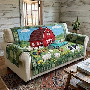 May include: A quilted sofa cover featuring a farm scene with a red barn, blue sky, and green truck. The cover includes images of sheep, chickens, and a cow. The cover has green plaid arm covers.