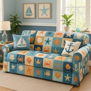 Può includere: Un divano trapuntato blu, arancione e beige con quadrati a tema nautico con conchiglie, stelle marine e ancore. Due cuscini con un design a forma di barca a vela e ancora. Due quadri incorniciati di una barca a vela e una stella marina.