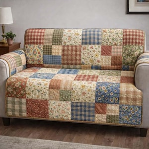 Może przedstawiać: Pokrowiec na sofę w stylu patchwork z różnorodnymi kwadratami we wzory w odcieniach czerwieni, niebieskiego, beżu i zieleni. Pokrowiec posiada kwadraty z tkanin kwiatowych, w kratę i gładkich, tworząc przytulną estetykę w stylu wiejskim.
