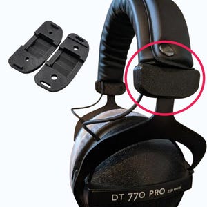 Pode incluir: Almofadas de ouvido de substituição pretas e um par de suportes de montagem de fone de ouvido pretos. Os fones de ouvido são pretos com o texto "DT 770 PRO 250 OHM" impresso na concha.