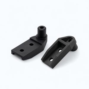 May include: Two black, 3D-printed brackets. One bracket has a cylindrical post and two holes. The other bracket has two holes and a rounded end. Both brackets are on a white background.