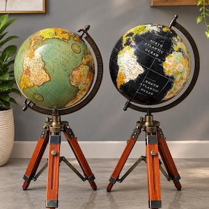 May include: Two floor globes mounted on adjustable wooden tripod stands with brass-toned metal hardware. One globe features a light green and tan map, while the other displays a black and white map with gold-toned text labels for oceans.