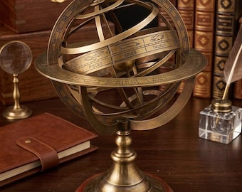 May include: A brass armillary sphere featuring concentric rings with engraved zodiac signs including Aries, Taurus, and Pisces. The celestial model is mounted on a circular wooden base with a metallic stand, displaying numerical degree markings.