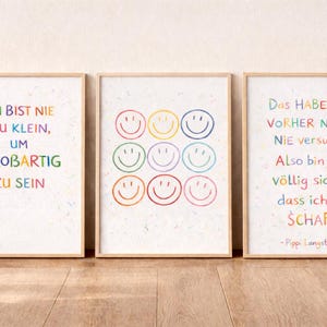 May include: Three framed art prints with motivational quotes and colourful smiley faces. The first print says "You are never too small to be great." The second print features nine smiling faces. The third print says "I have never tried it before, so I am quite sure I can do it!"