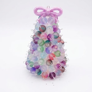May include: A cone-shaped decorative ornament constructed from numerous frosted, multi-colored beads in shades of purple, blue, green, and pink. The beads are attached with silver-toned metal loops, and the top is finished with a light pink bow.