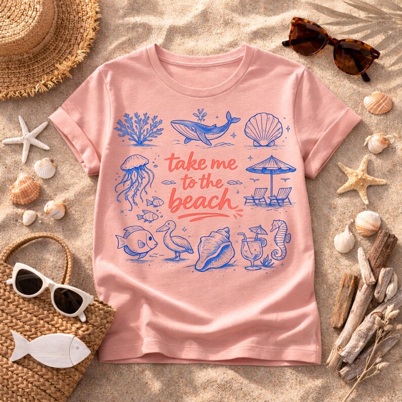 K&ouml;nnte beinhalten: Hellrosa T-Shirt mit Strandmotiv. Das Design zeigt blaue Illustrationen von Meereslebewesen, einen Sonnenschirm und den Text "take me to the beach". Das T-Shirt ist von Strandaccessoires umgeben.