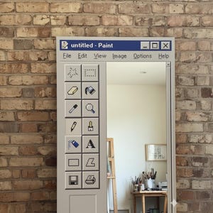 May include: A rectangular mirror framed in light gray, designed to resemble the classic Windows Paint application interface. The mirror features a toolbar with various icons and the title "untitled - Paint". The background is a brick wall.