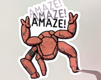 May include: A die-cut sticker featuring a reddish-brown, segmented, robotic creature with four limbs, each ending in a peace sign gesture. The text "AMAZE!" is printed in black and light purple stacked above the creature on a white background.