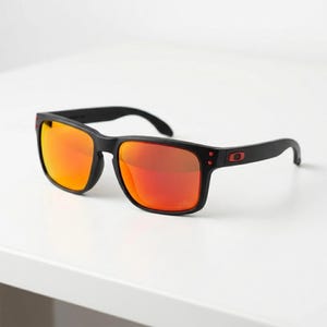 May include: Black sunglasses with red mirrored lenses. The sunglasses have a square frame and a sleek, modern design. The temples feature a small red accent. The lenses reflect a vibrant orange and red gradient.