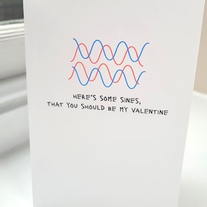 Puede incluir: Tarjeta de felicitación blanca con gráficos de ondas sinusoidales azules y rojas. La tarjeta dice: "HERE'S SOME SINES, THAT YOU SHOULD BE MY VALENTINE". Una tarjeta romántica para San Valentín.