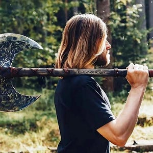 May include: A large, double-bladed axe with a weathered wooden handle and intricate metalwork on the blades. The handle is wrapped with brown leather. The axe is held over the shoulder against a blurred forest background.