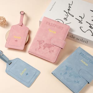 May include: Two passport holders and two luggage tags in pink and blue. The pink set is personalized with the name Sarah and the blue set with James. Each item features a world map graphic, an airplane icon, and the word PASSPORT in gold text.