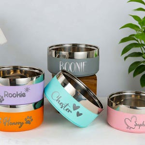 May include: A white ceramic mug with a black handle and the text "But First, Coffee" in a bold, black font. The mug is set against a blurred background, suggesting a cozy setting.