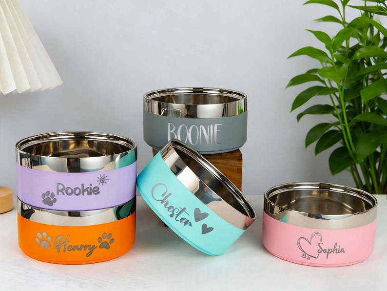 May include: A white ceramic mug with a black handle and the text "But First, Coffee" in a bold, black font. The mug is set against a blurred background, suggesting a cozy setting.