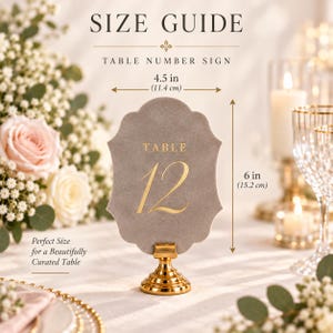 May include: A grey velvet table number sign with gold lettering reading TABLE 12, mounted on a gold metal stand. The sign measures 4.5 inches wide by 6 inches high. The text SIZE GUIDE and TABLE NUMBER SIGN are printed above the sign.