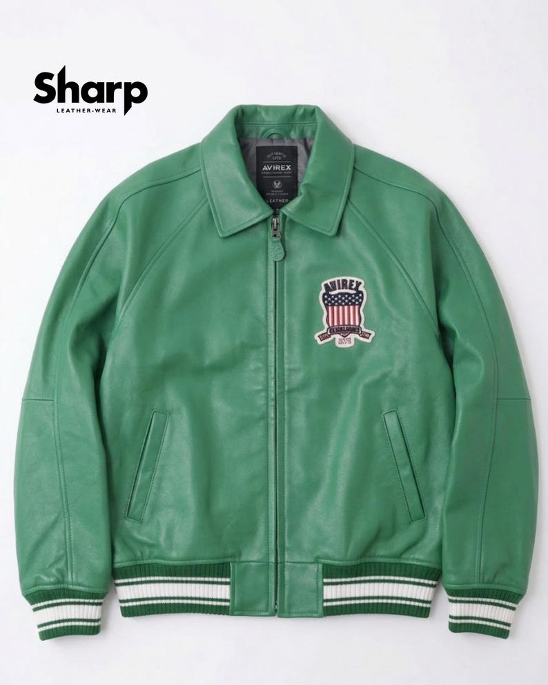 May include: Green leather jacket with a zip-up front, a collar, and a patch on the chest. The jacket has white and green striped cuffs and a white and green striped hem. The brand name "Sharp Leather Wear" is in the top left corner.