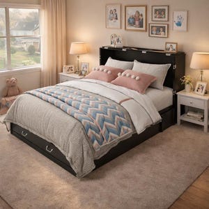 May include: A black bed frame with a pull-out drawer, a white and blue patterned quilt, and pink pillows. The bed is in a bedroom with a window, lamps, and framed photos on the wall.