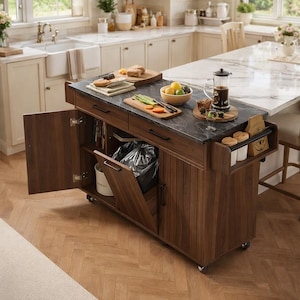 May include: A dark wood kitchen island with a dark gray countertop. The island has a built-in trash can, drawers, and a side shelf. The countertop holds a cutting board with vegetables, a bowl of fruit, and a coffee press. The island is on wheels.