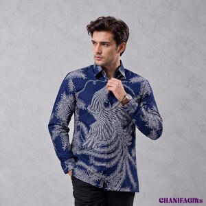 Puede incluir: Una camisa de manga larga con botones en azul oscuro que presenta un patrón de fénix y hojas en blanco. La camisa tiene un cuello clásico, frente abotonado y puños con botones. El texto CHANIFAGifts aparece en la esquina inferior derecha.