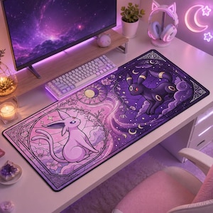 May include: A rectangular desk mat featuring a split-design illustration of two fictional creatures. The left side shows a light purple creature in a pink circular frame, while the right side displays a black creature in a dark purple circular frame.