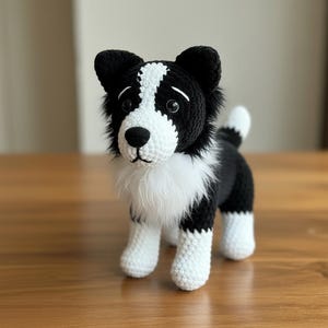 May include: A handmade crochet dog in black and white, resembling a Border Collie. The plush toy features a white face, chest, and paws, with black ears and body. The dog has a fluffy white collar and a small white tail. The toy is standing on a wooden surface.