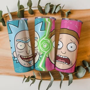May include: Three stainless steel tumblers featuring cartoon character designs. One tumbler is light blue with a Rick face, the second is green and white with a portal design, and the third is pink with a Morty face. Each tumbler has a silver lid.