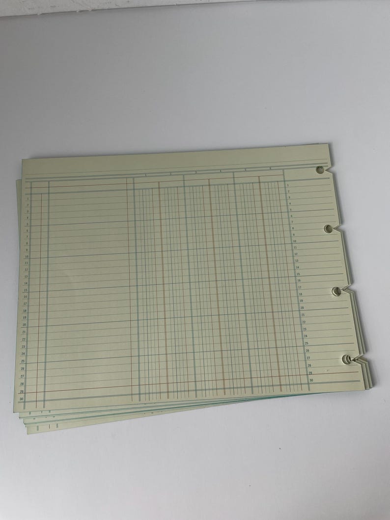 May include: A stack of ledger sheets with a pale green background. The sheets have horizontal and vertical lines creating columns and rows. The sheets are perforated on the left side with three holes for binding. The lines are in blue, red, and green.