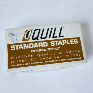 May include: A white box with gold lettering that reads "QUILL STANDARD STAPLES CHISEL POINT another quality product priced to save you money QUILL CORP. 100 8. SCHELTER RD. LINCOLNSHIRE, IL 60069 (312) 634-4800".